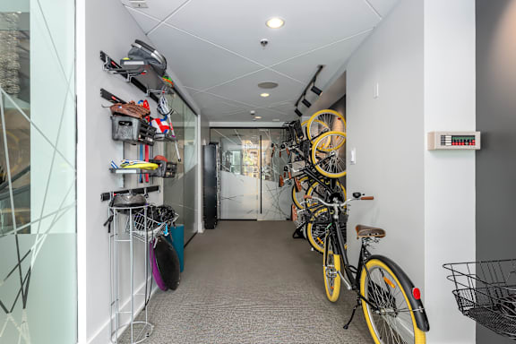 A hallway with bicycles on the right and a bike rack on the left at Clayton on the Park Apartments, Clayton, MO, 63105