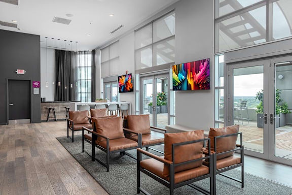 A waiting area with brown leather chairs and a large painting on the wall at Clayton on the Park Apartments, Clayton, MO