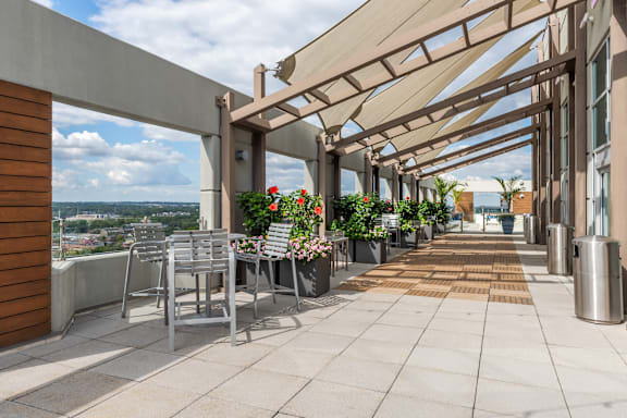 A patio with a table and chairs under a roof at Clayton on the Park Apartments, Clayton, MO