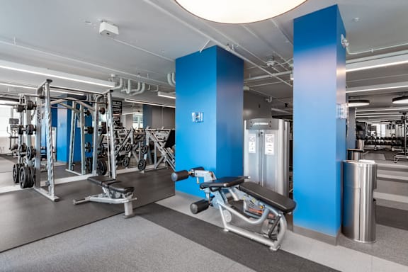 A gym with a variety of equipment including a leg press machine at Clayton on the Park Apartments, Clayton, Missouri