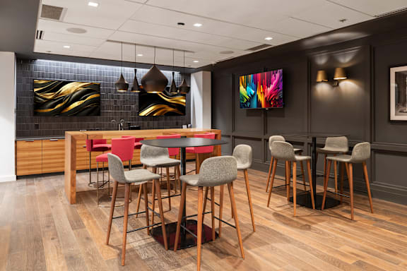 A modern dining room with a wooden table and chairs at Clayton on the Park Apartments, Clayton, Missouri