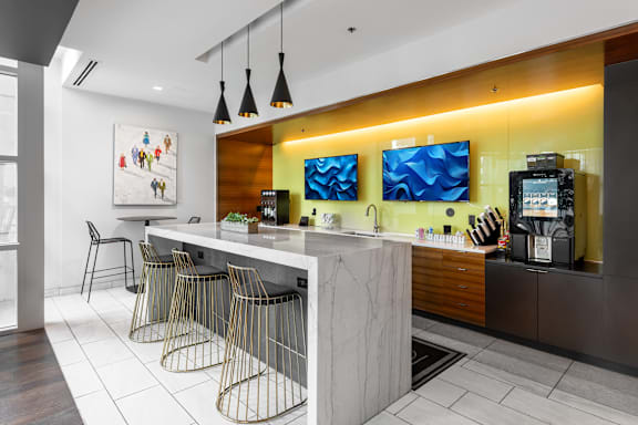 A modern kitchen with a bar area and a painting on the wall at Clayton on the Park Apartments, Clayton, MO