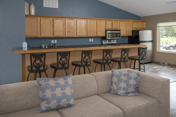a living room with a couch and a kitchen with a bar