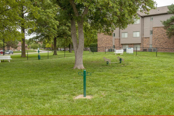 a cross in the grass near a tree in a park