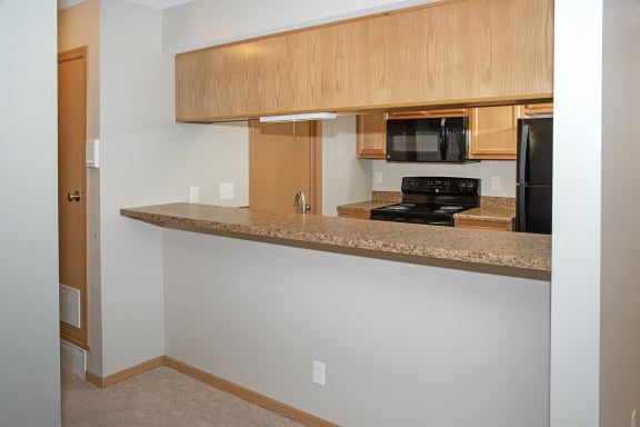a kitchen with a counter top and a stove and a microwave