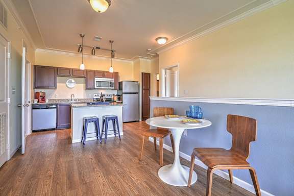 a living room with a table and chairs and a kitchen