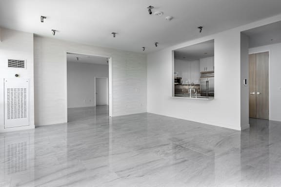 A white room with a marble floor and a kitchen in the background at Clayton on the Park Apartments, Missouri, 63105