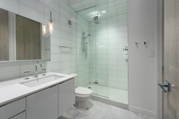 A white bathroom with a glass shower stall. at Clayton on the Park Apartments, Clayton, Missouri