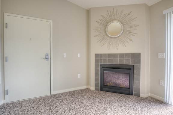 an empty living room with a fireplace and a door