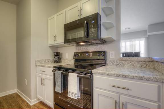 a kitchen with granite counter tops and a stove and microwave