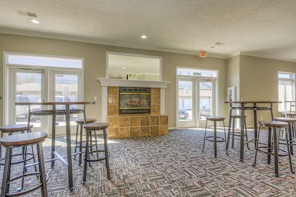 a community room with bar stools and a fireplace