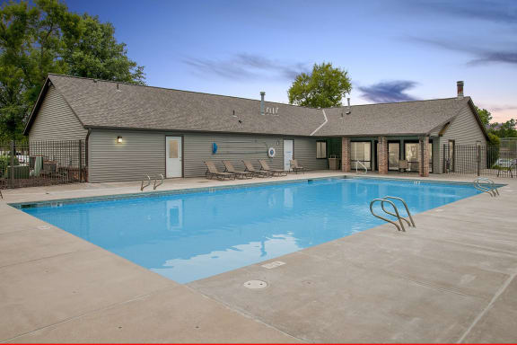 a swimming pool with a house in the background