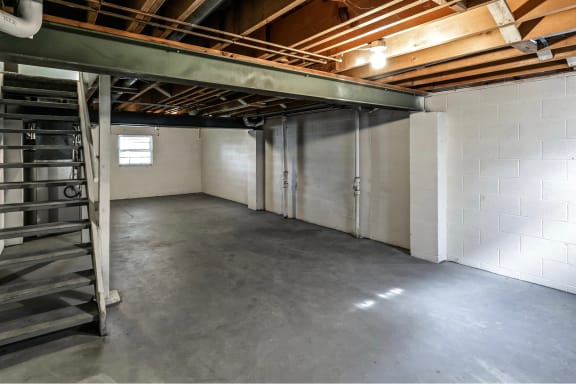 the interior of a garage with a concrete floor and white walls
