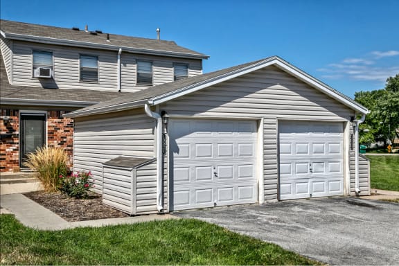 a garage with two doors in front of a house