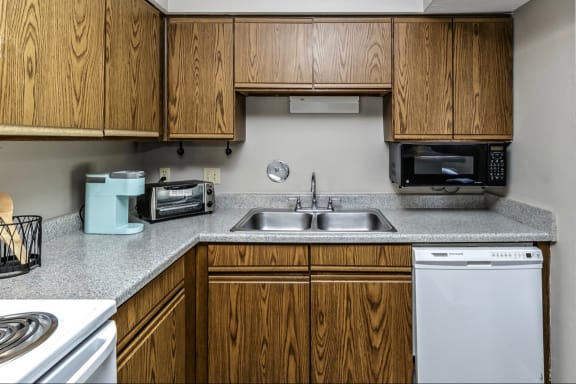 an empty kitchen with wooden cabinets and a sink and a stove