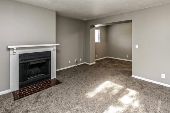 a living room with a fireplace and a carpeted floor