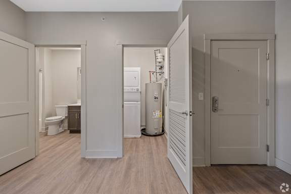 A white door is open to a bathroom with a toilet and sink.
