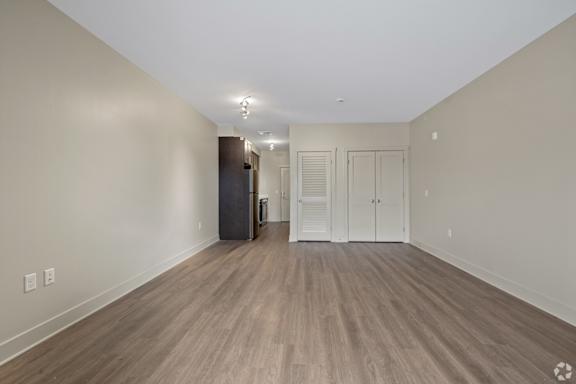 A room with wooden flooring and white walls.