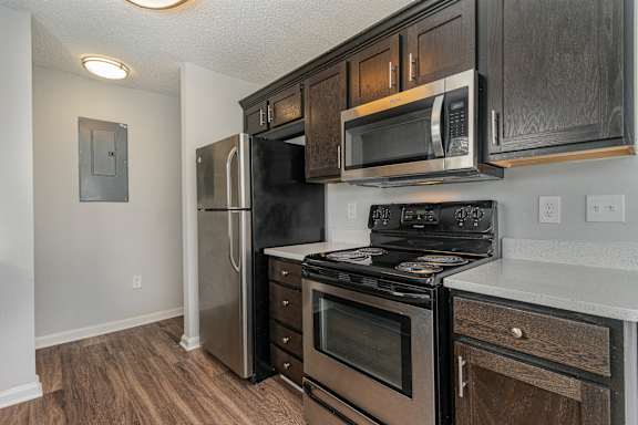 A kitchen with a stove, oven, microwave, and refrigerator.