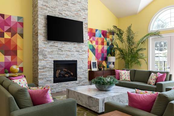 A living room with a fireplace and a flat screen TV mounted above it.