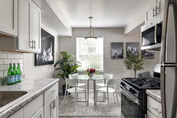 A kitchen with a table and chairs in the middle of the room.