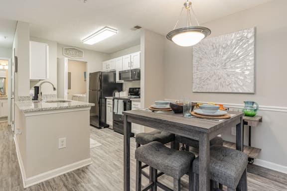 our model home has an open floor plan with a dining room table and a kitchen at Litchfield Oaks Apartments, South Carolina
