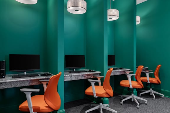 A room with green walls and a row of orange chairs.