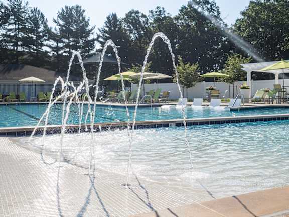 A pool with a fountain in the middle of it.