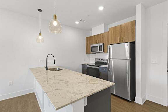 A kitchen with a granite countertop and stainless steel appliances.