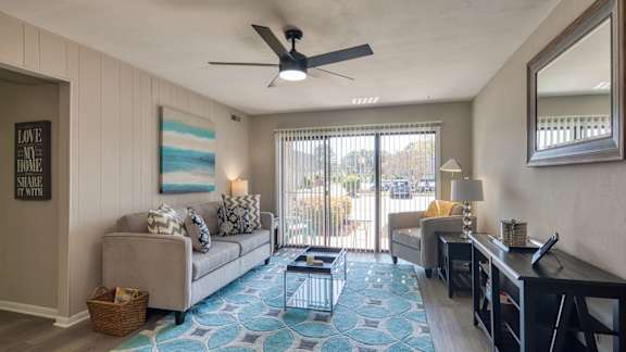 a living room with a couch and a desk and a ceiling fan  at Bayville Apartments, Virginia Beach, VA, 23455
