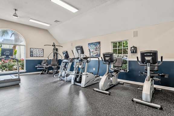 A gym with treadmills, exercise bikes, and elliptical machines.