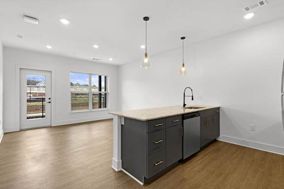 A kitchen with a large island and a view of a backyard through the windows.