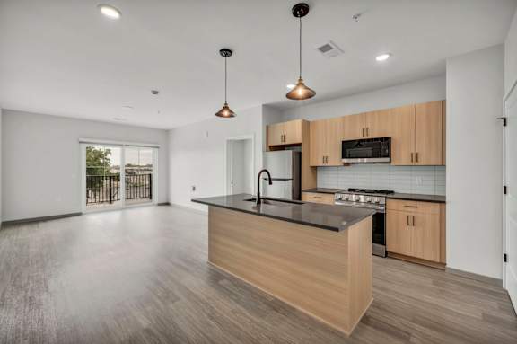 A modern kitchen with a wooden island and pendant lights.