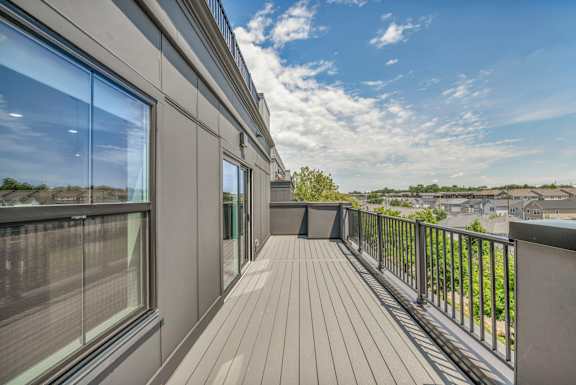 A balcony with a wooden floor and a metal railing.