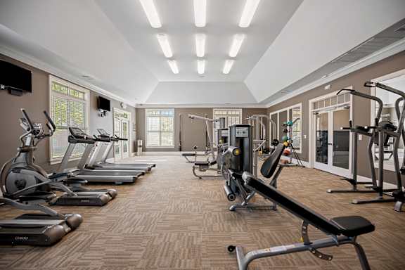 A gym with treadmills, elliptical machines, and weight machines.