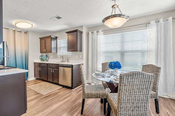 A modern kitchen with a dining table set for two.