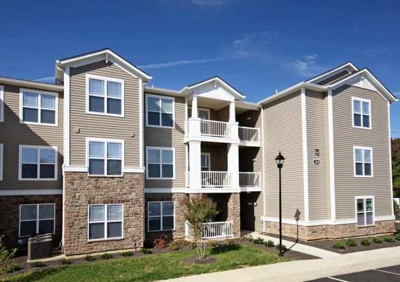 an apartment building with tan siding and a tan brick wallat Addison Crater Woods, Petersburg Virginia