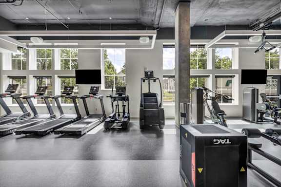 A gym with treadmills, elliptical machines, and other exercise equipment.