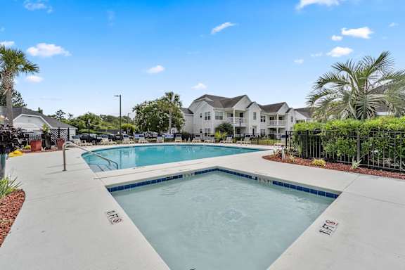 A swimming pool in a residential area with houses in the background.