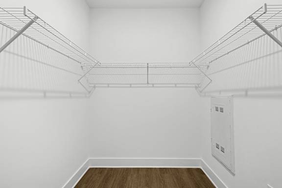 A white room with a wood floor and empty shelves.