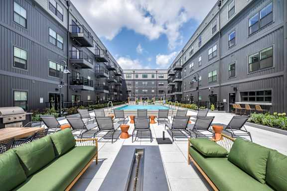 A large outdoor seating area with green couches and tables.