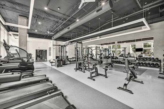 A gym with treadmills, weights, and other exercise equipment.