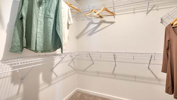 Clothes hanging on a rack in a room.
