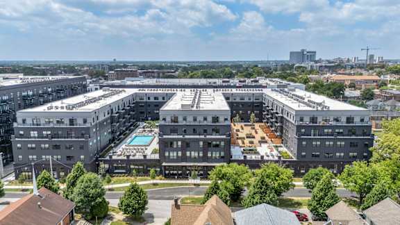 A large, modern building complex with a pool in the center.