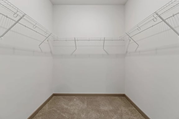 a white room with wire shelving on the wall and a carpetat Metropolis Apartments, Glen Allen Virginia