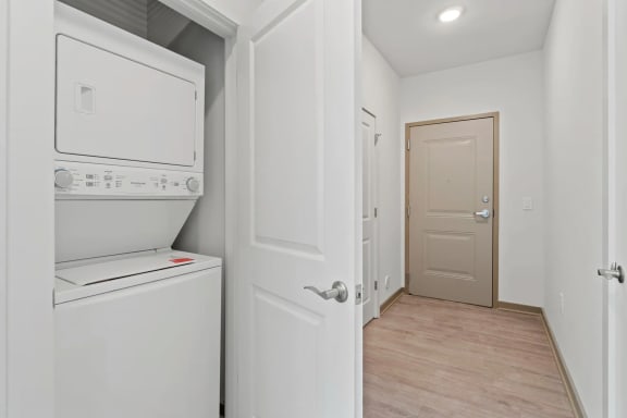 a white laundry room with a white washer and dryer and a white doorat Metropolis Apartments, Virginia, 23060