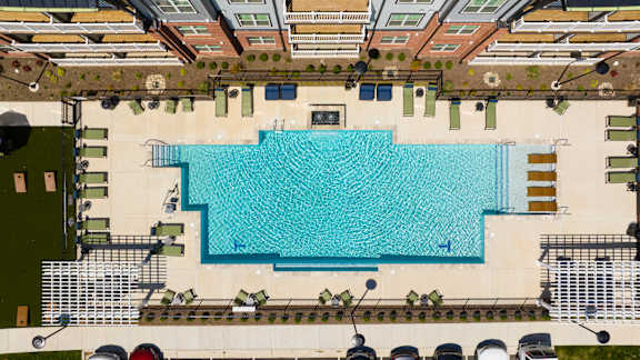 An aerial view of a swimming pool surrounded by a fence.