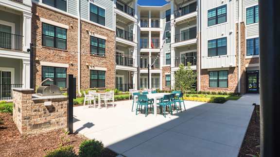 A sunny day at a courtyard with a white table and chairs.