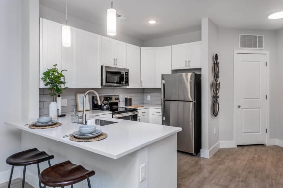 a kitchen with an island and a stainless steel refrigerator at Centro at Pine Nash in Wilson, North Carolina 27893