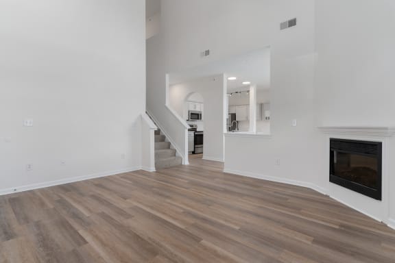 a living room with white walls and a fireplace and wooden floors at The Charleston, Columbus
